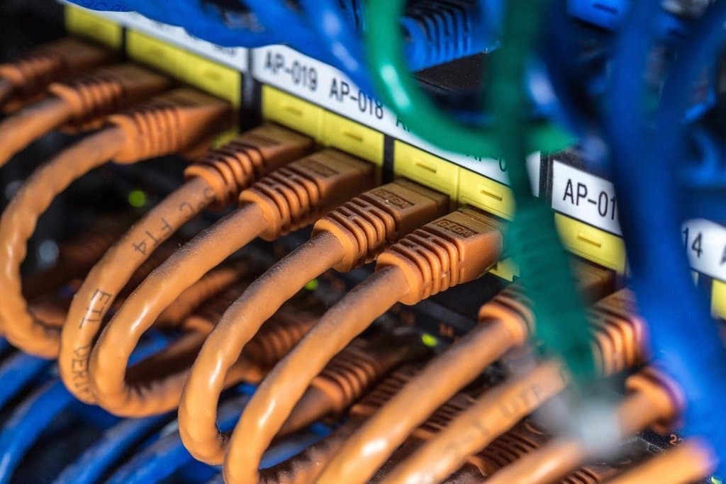 Network cables plugged into a patch panel in a server rack.